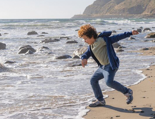 A child dabbing towards the water of Deer Creek Beach.