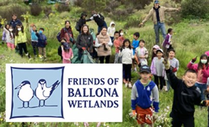Kids trekking through the Ballona Wetlands, surrounded by greenery. The Friends of Ballona Wetlands logo is over the photo in the bottom left corner.