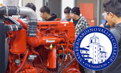 A large red engine in the foreground with trainees in the background and on the right of the image. The San Bernardino Valley College Foundation Logo is over the bottom right corner.