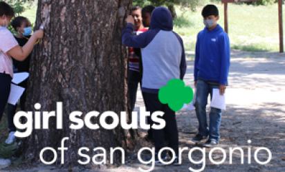Kids standing around a tree on the left side of the frame. Girls Scouts of san gorgonio written across the bottom.