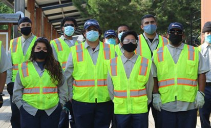 Orange County Conservation Corps workers in neon yellow vests posing as a group.